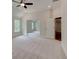 Bright bedroom featuring a ceiling fan, two windows, and an adjoining room with neutral carpet at 3292 Mill Forest Sw Dr, Conyers, GA 30094