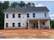 New home's back exterior features a covered patio, multiple windows, and brick foundation at 3292 Mill Forest Sw Dr, Conyers, GA 30094