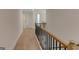 Upstairs hallway with hardwood floors and a decorative railing at 3292 Mill Forest Sw Dr, Conyers, GA 30094