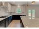 Stylish kitchen showcasing granite counters, gas cooktop, white subway tile backsplash, and stainless hood at 3292 Mill Forest Sw Dr, Conyers, GA 30094