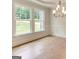 Bright living area featuring large windows, decorative molding, and gleaming hardwood floors at 3292 Mill Forest Sw Dr, Conyers, GA 30094