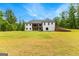 Expansive backyard featuring a lush lawn, white siding and covered patio with picturesque wooded backdrop at 155 Grace Hope Dr, Brooks, GA 30205