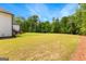 Expansive backyard featuring well maintained lawn, professional landscaping, and lush trees at 155 Grace Hope Dr, Brooks, GA 30205