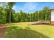Wide-open backyard featuring lush lawn, landscaping and a wooden retaining wall at 155 Grace Hope Dr, Brooks, GA 30205