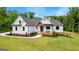 Charming white farmhouse with inviting front porch and beautifully landscaped garden beds at 155 Grace Hope Dr, Brooks, GA 30205