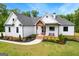 Charming two-story home with a landscaped front yard, brick stairs, and covered porch at 155 Grace Hope Dr, Brooks, GA 30205