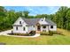 Beautiful modern farmhouse with white siding, manicured lawn, covered porch and professional landscaping at 155 Grace Hope Dr, Brooks, GA 30205