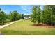 A spacious home with a long driveway surrounded by lush green lawn and mature trees at 155 Grace Hope Dr, Brooks, GA 30205