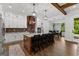 Well-lit kitchen with island seating, stainless appliances, white cabinets, and brick backsplash at 155 Grace Hope Dr, Brooks, GA 30205