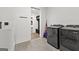 Bright laundry room features sleek appliances, tile flooring, utility sink, and convenient access to mudroom at 155 Grace Hope Dr, Brooks, GA 30205