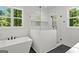 Bright bathroom boasts a frameless glass shower, soaking tub, large window, and modern finishes at 155 Grace Hope Dr, Brooks, GA 30205