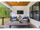 Inviting covered patio featuring comfortable wicker seating, TV, and a beautifully stained wood ceiling at 155 Grace Hope Dr, Brooks, GA 30205