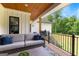 Relaxing outdoor living space with wicker couch, overlooking the backyard's lush greenery and professional landscaping at 155 Grace Hope Dr, Brooks, GA 30205