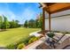 Inviting covered porch with lovely landscaping overlooking expansive lawn and distant house at 155 Grace Hope Dr, Brooks, GA 30205