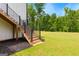 Wooden stairs with black metal railing leading to a lush lawn and backyard at 155 Grace Hope Dr, Brooks, GA 30205