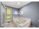 Relaxing bathroom featuring a bathtub, window, walk-in shower, and tiled floor at 1533 High Haven Ne Ct, Atlanta, GA 30329