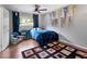 Bedroom showcasing hardwood floors, window with blue curtains, and wall pennants at 1533 High Haven Ne Ct, Atlanta, GA 30329