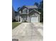 Charming two-story home with a one-car garage and a spacious concrete driveway with a well-manicured lawn at 2317 Hackamore Dr, Atlanta, GA 30349