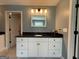 Bathroom featuring a black granite countertop, white cabinets, and contemporary lighting, providing a luxurious experience at 8340 Nolandwood Ln, Villa Rica, GA 30180