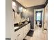 Modern bathroom featuring double vanity, round mirrors, updated fixtures, and decorative chevron backsplash at 8340 Nolandwood Ln, Villa Rica, GA 30180
