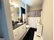 Charming bathroom with a modern vanity, decorative mirror, and stylish shower curtain at 8340 Nolandwood Ln, Villa Rica, GA 30180