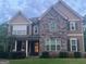 Charming two-story home with stone and wood siding and inviting front porch with chairs at 8340 Nolandwood Ln, Villa Rica, GA 30180