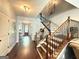 Grand foyer with dark wood floors, an elegant chandelier, and a beautiful staircase with iron spindles at 8340 Nolandwood Ln, Villa Rica, GA 30180