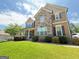 Charming two-story home featuring a stone facade, manicured lawn, and inviting front porch at 8340 Nolandwood Ln, Villa Rica, GA 30180