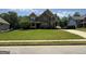 Two-story home with stone facade, a lawn, and a long driveway with multiple cars at 8340 Nolandwood Ln, Villa Rica, GA 30180