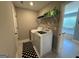 Functional laundry room with modern washer and dryer, storage shelf, and convenient access to the bathroom at 8340 Nolandwood Ln, Villa Rica, GA 30180