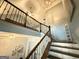 Upward view of a staircase with beautiful wooden railings and landing, showcasing the home's height at 8340 Nolandwood Ln, Villa Rica, GA 30180