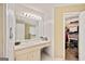 Bright bathroom showcasing a vanity with a large mirror and a walk-in closet at 160 Country Mill Ln, Stockbridge, GA 30281
