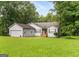 Charming home with a well-manicured lawn and a welcoming front porch, set against a backdrop of mature trees at 160 Country Mill Ln, Stockbridge, GA 30281