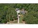 Aerial view of a private, wooded estate with a large main house and detached garage at 193 Stonegate Trl, Carrollton, GA 30116
