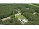 An aerial view of a private estate featuring a community pool, pool house, and dense surrounding trees at 193 Stonegate Trl, Carrollton, GA 30116