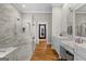 Bathroom with tiled walk-in shower, marble vanity, and wood floors at 193 Stonegate Trl, Carrollton, GA 30116