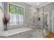 Bright bathroom with a tub, a large window, and a glass-enclosed shower at 193 Stonegate Trl, Carrollton, GA 30116