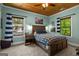 Bedroom features a wooden bed frame, a ceiling fan, and two windows with light blue walls at 193 Stonegate Trl, Carrollton, GA 30116