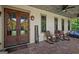Covered porch with rocking chairs, hanging plants, wood flooring, and a rustic metal ceiling at 193 Stonegate Trl, Carrollton, GA 30116