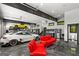 Upscale garage with multiple cars, car lifts, stylish seating area and sleek, modern design elements at 193 Stonegate Trl, Carrollton, GA 30116