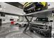 Spacious and organized garage featuring a car lift, modern vehicles, and a well-lit environment at 193 Stonegate Trl, Carrollton, GA 30116