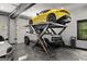 State-of-the-art garage featuring a car lift with a yellow sportscar, along with multiple other vehicles at 193 Stonegate Trl, Carrollton, GA 30116