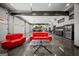 Spacious garage with multiple cars, a car lift, stylish red seating area, and modern organizational elements at 193 Stonegate Trl, Carrollton, GA 30116