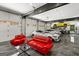 Luxurious garage featuring multiple cars, car lifts, a comfortable lounge area, and a polished epoxy floor at 193 Stonegate Trl, Carrollton, GA 30116