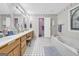 Spacious bathroom with dual sinks, a soaking tub, and patterned wallpaper at 392 Hightower Ridge Rd, Covington, GA 30014