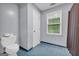 Bathroom showcasing a toilet, window, and shower with a neutral curtain at 392 Hightower Ridge Rd, Covington, GA 30014