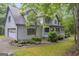 Side view of home with a well-maintained lawn, a pond, and an attached garage at 392 Hightower Ridge Rd, Covington, GA 30014