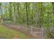 Chain link fence encloses a wooded area featuring mature trees and small structure at 392 Hightower Ridge Rd, Covington, GA 30014
