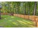 A well-maintained backyard, complete with a playset, and surrounded by lush greenery and a wooden fence at 111 Rosignol Dr, Sharpsburg, GA 30277