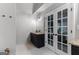 Stylish bathroom with a dark vanity, granite counters and french doors to the bedroom at 111 Rosignol Dr, Sharpsburg, GA 30277